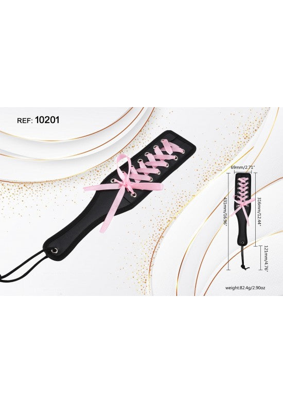 Paleta de disciplina negra con decoración de cordones y lazo de raso rosa